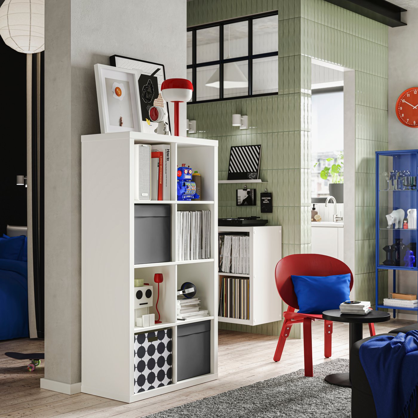 A light room with neatly organised white KALLAX shelving units, complemented in some of its compartments with DRÖNA boxes.
