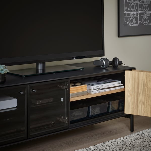 Szafka pod TV BOASTAD, czarny/okl dęb, 121x42 cm z otwartymi drzwiami.