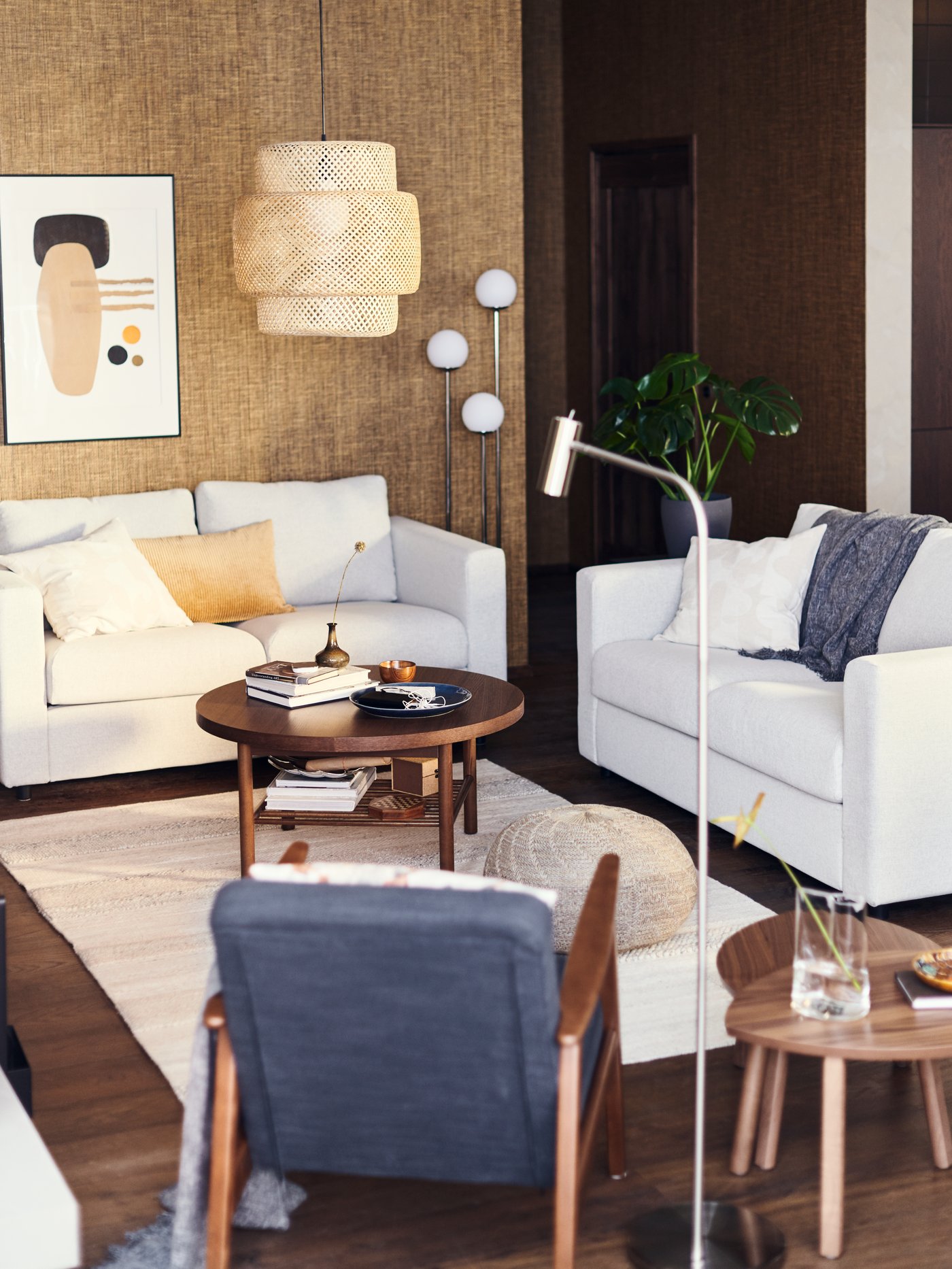 Salón con un sofá de dos plazas, una lámpara de lectura de pie, un sillón, mesas anidadas, una lámpara de techo y una mesa de centro.