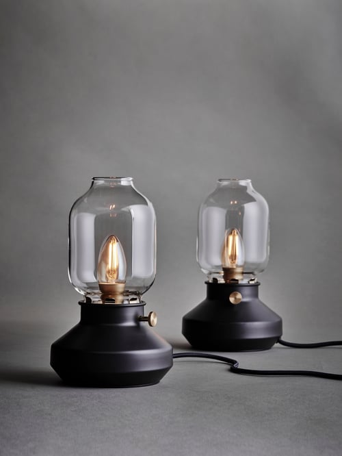 Grey background with two anthracite table lamps with glass shades and dimmable LED light bulbs inside.