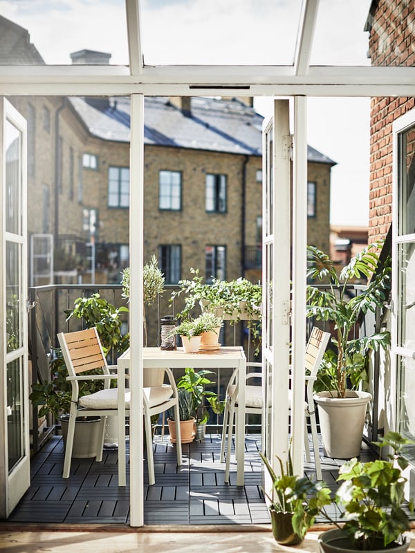 un balcon aménagé avec des plantes et du mobilier d'extérieur