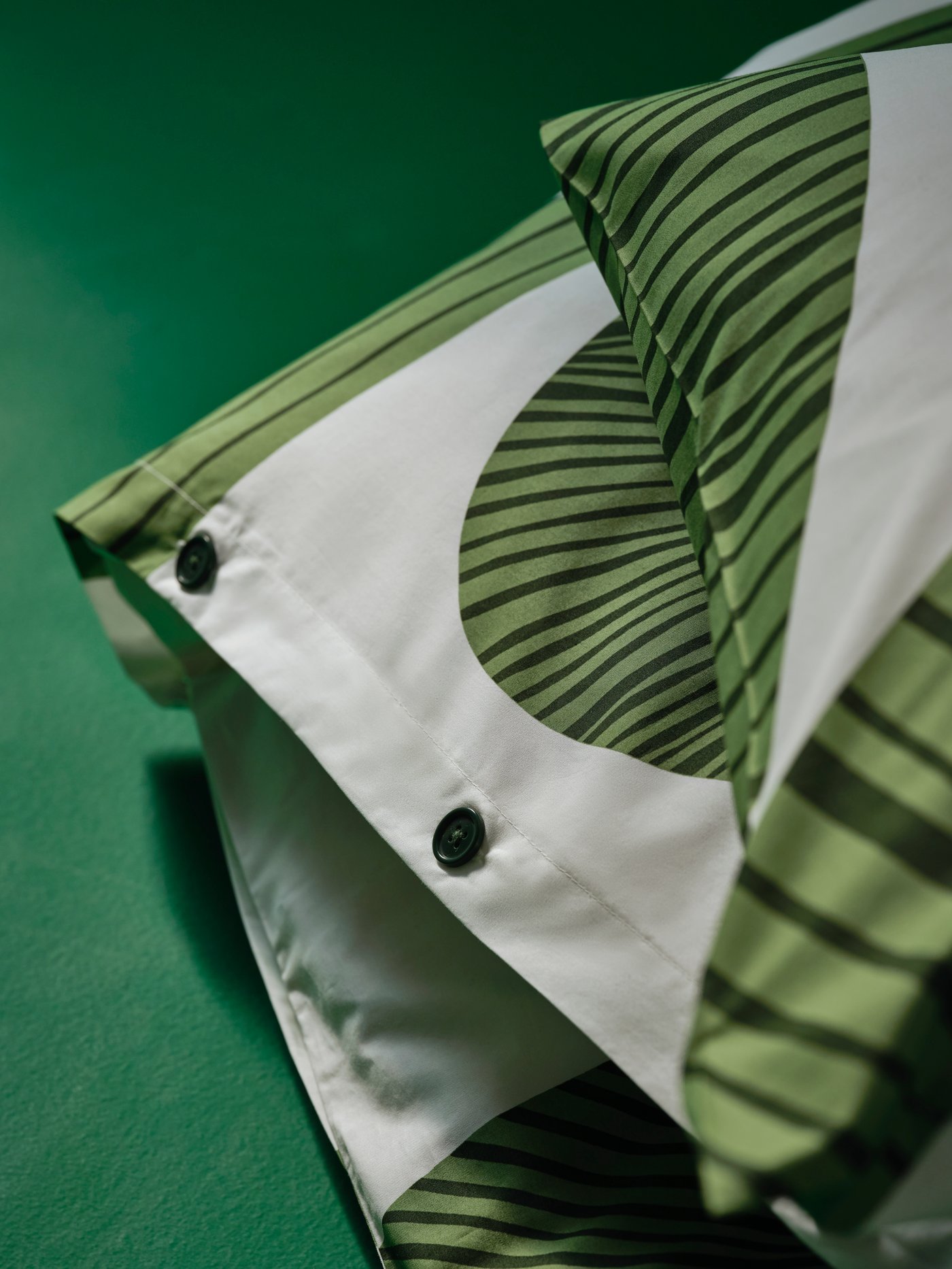Bundled bedding with the leafy-pattern, white-and-green KUNGSCISSUS duvet cover and pillowcase combination.