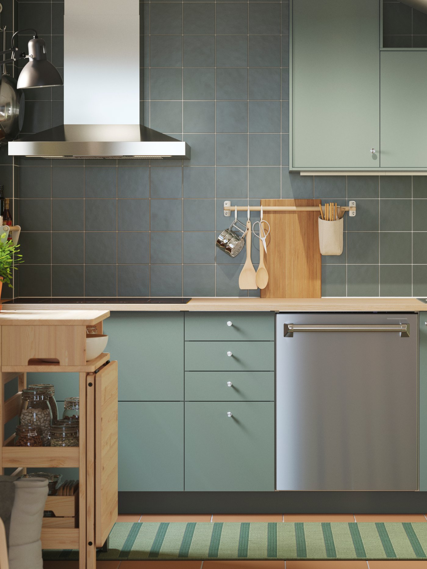 Une cuisine équipée d’armoires inférieures et murales aux façades NICKEBO au fini vert-gris mat ainsi que d’une table à abattants mobile RESARÖ avec rangement.