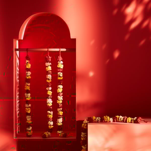 A red doorway with a rail, and strings of flowers hanging down.