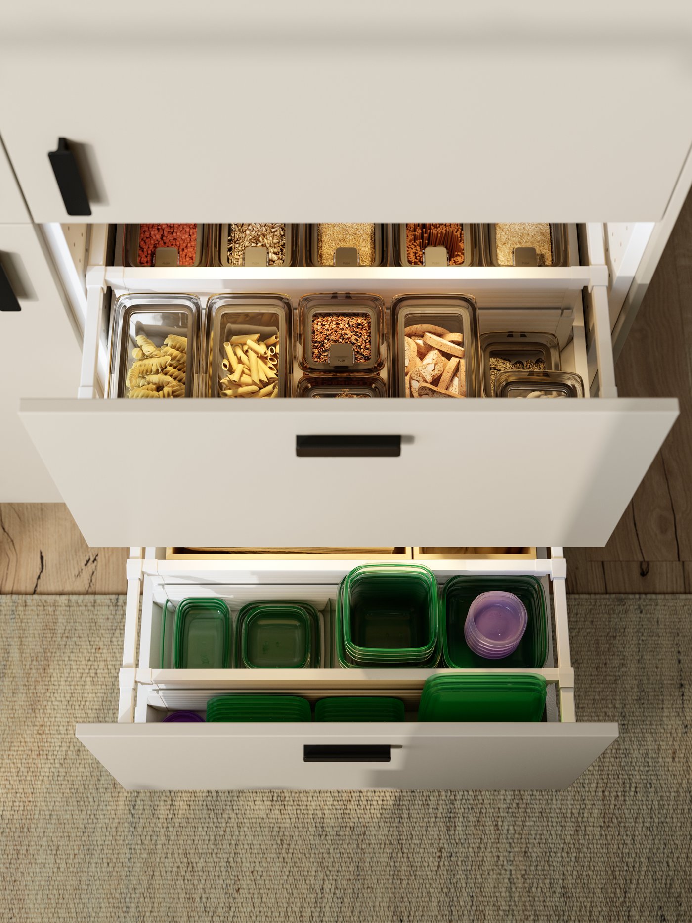 Two drawers in a SEKTION kitchen cabinet with beige HAVSTORP fronts are pulled out and there are interior organisers inside.