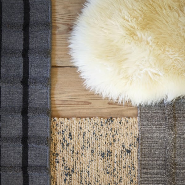 A handmade grey/black FOULUM rug, flatwoven in the living room