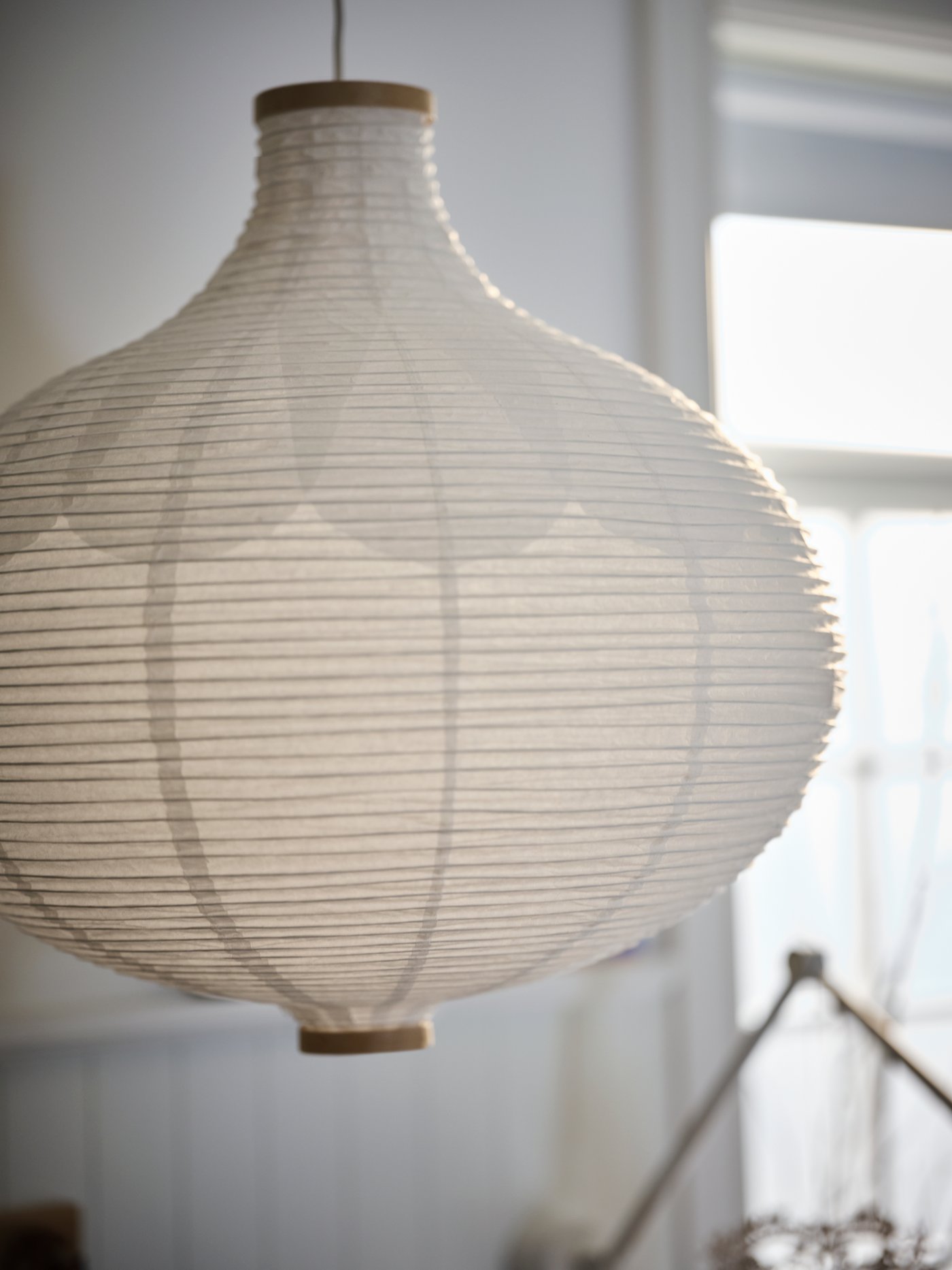 En RISBYN taklampskärm i vit, lökliknande form.