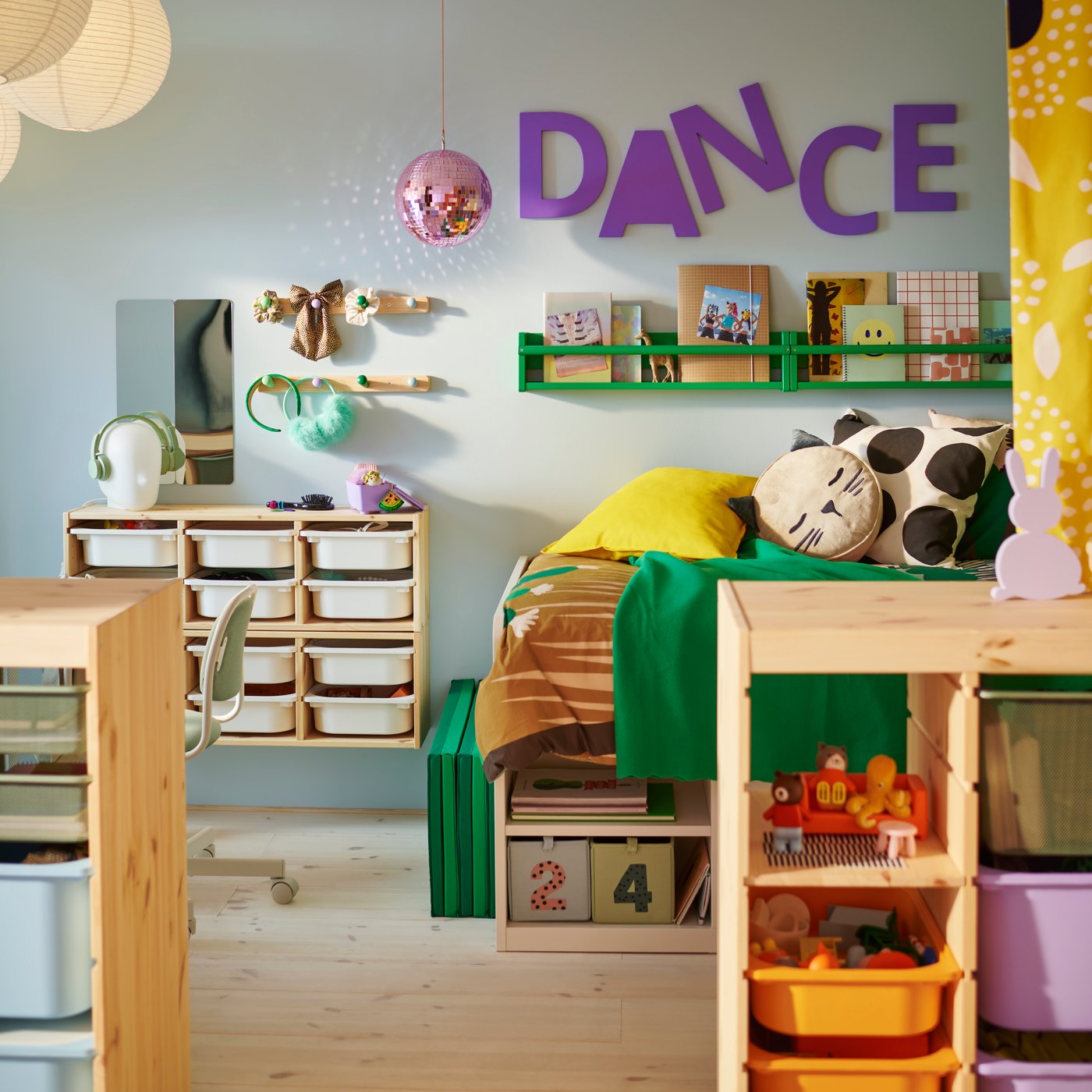 One side of a shared children’s bedroom divided by a TROFAST room divider showing a SLÄKT bed and FLISAT wall storage.