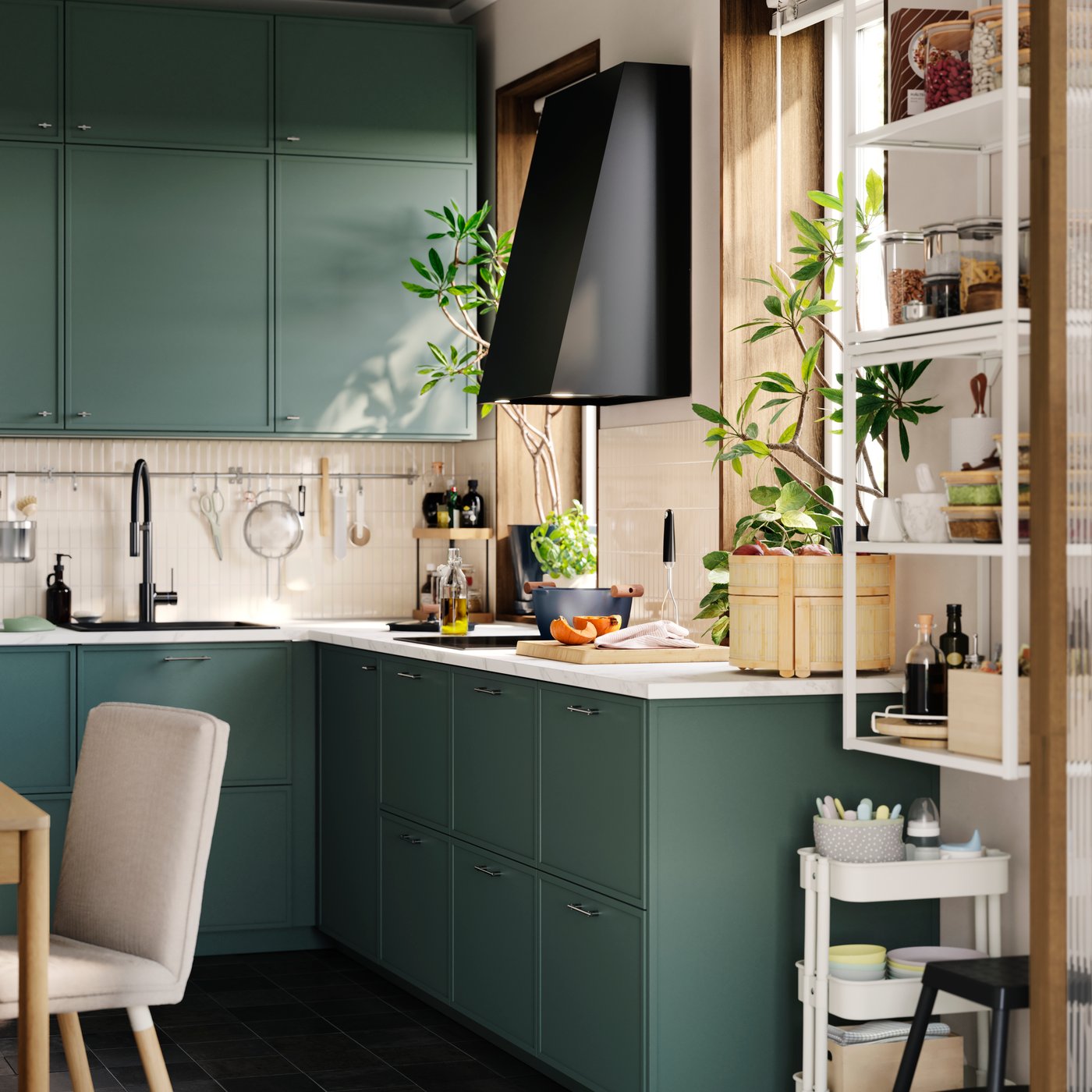 A small kitchen has several base and wall cabinets with grey-green ASPUDDEN fronts and an extractor hood next to a window.