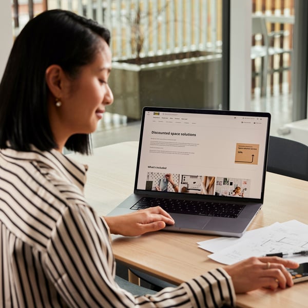ノートPCと資料が置かれた、明るいワークスペースのテーブル