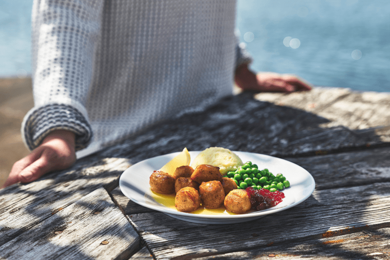 Stekte og crunchy fiskeboller med potetmos og grønne erter, smør og tyttebær.
