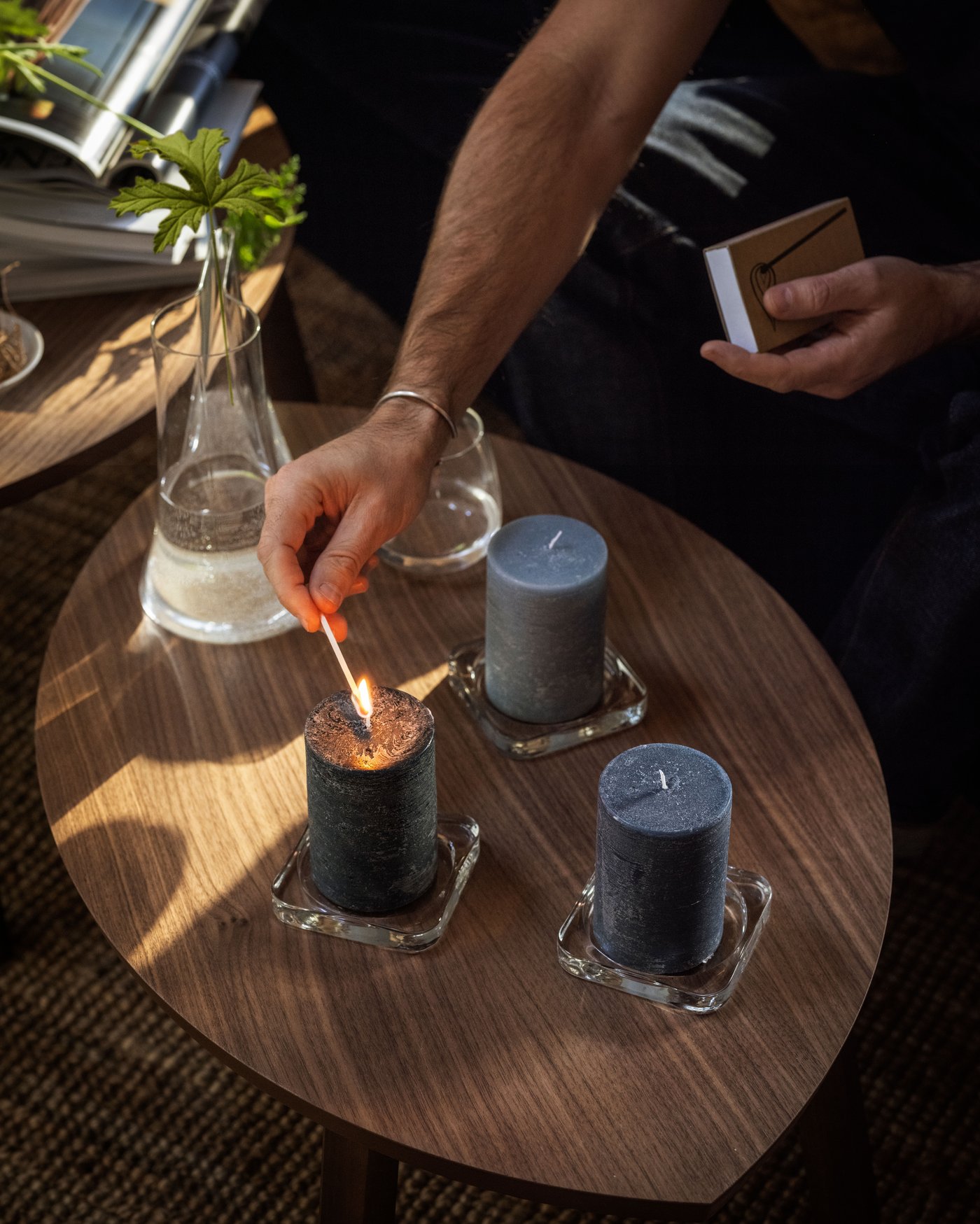 Ett FRUKTSKOG doftljus i svart och turkos med doft av vetiver och geranium i vardagsrummet.