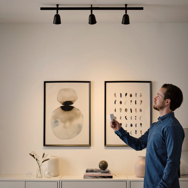 Een man met een draadloze TRÅDFRI dimmer in zijn hand 