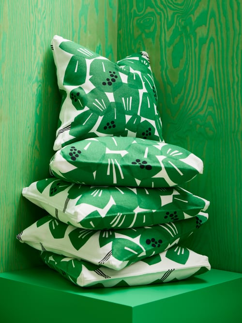 Outdoor featuring multiple square white and green UNDERBLOMMA cushion covers made of cotton and jute.