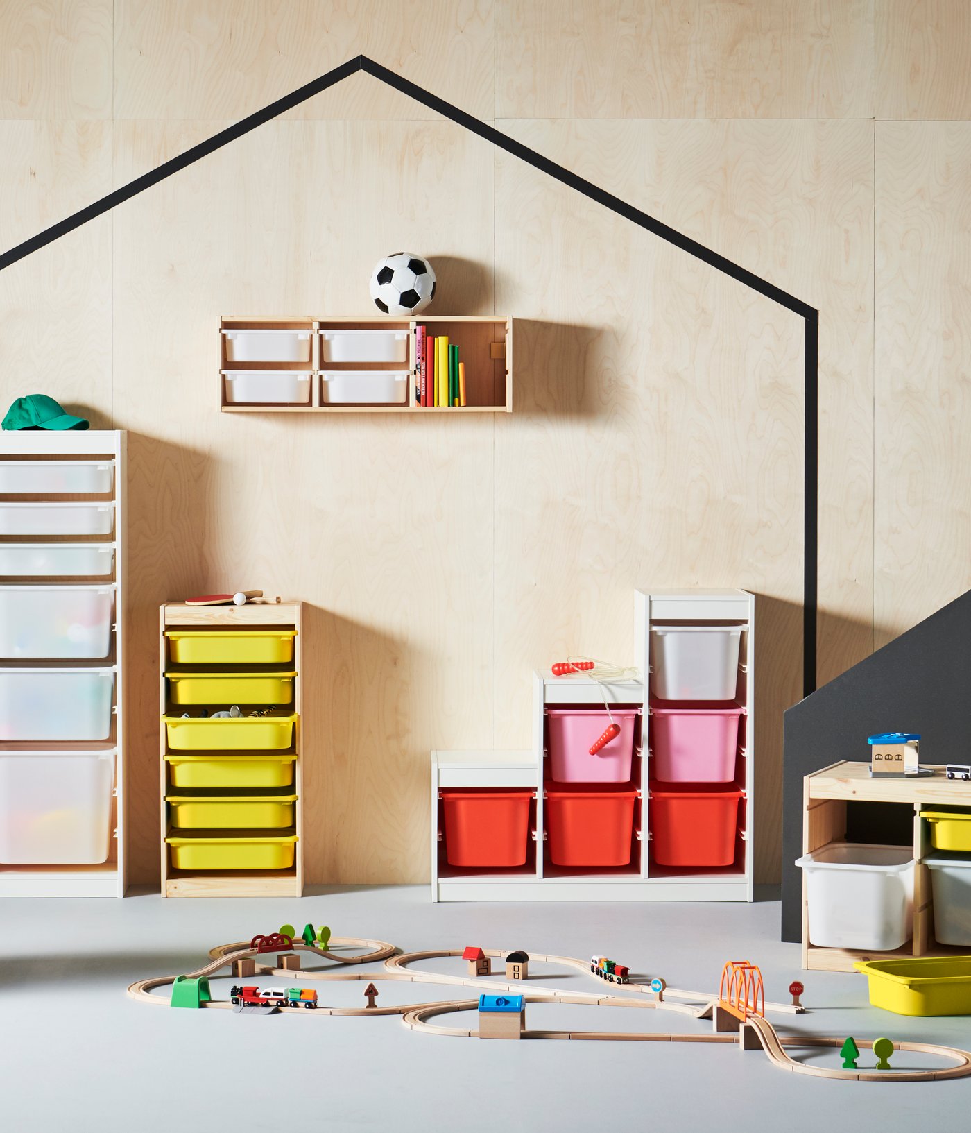 Different storage solutions from the TROFAST system placed side by side in front of a wooden wall