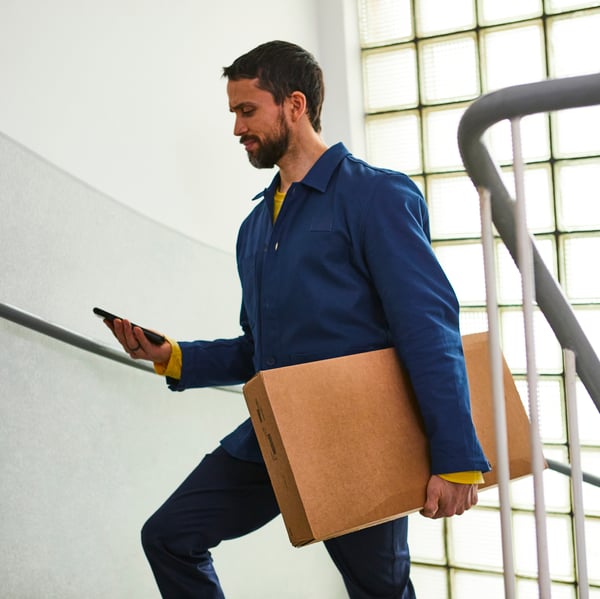 Ein Postbote bringt ein IKEA Paket