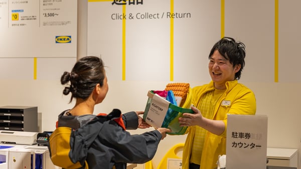 コワーカー（従業員）がお客様に商品を手渡している。