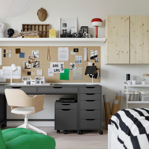An overview of a small student apartment with the ALEX desk and drawer units in the center, with a swivel chair in the front.