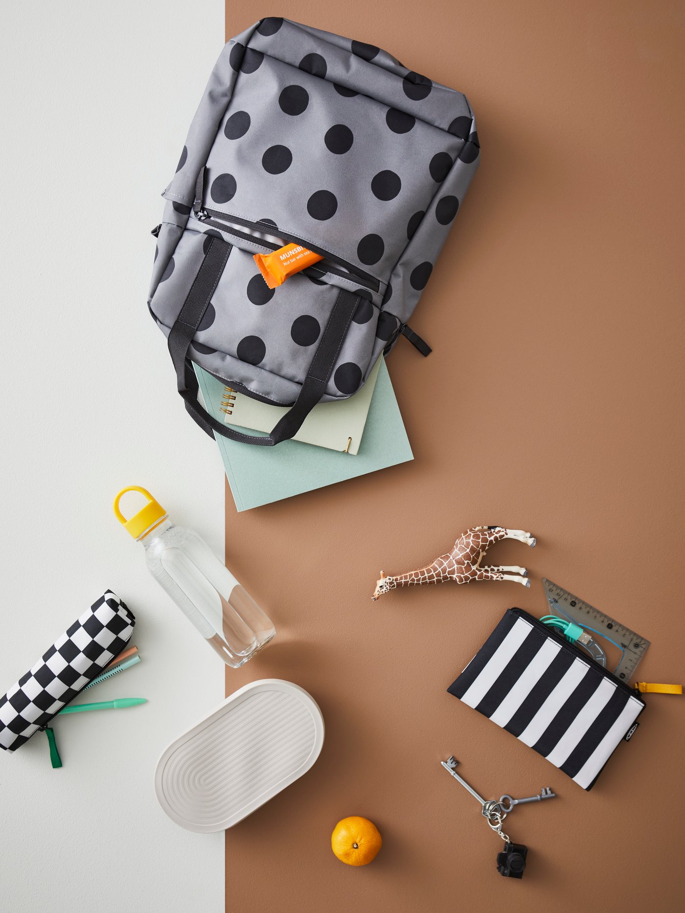 A STARTTID bag with notebooks spilling out. A pencil case, a FORMSKÖN water bottle and HALVVARM food container to the side.