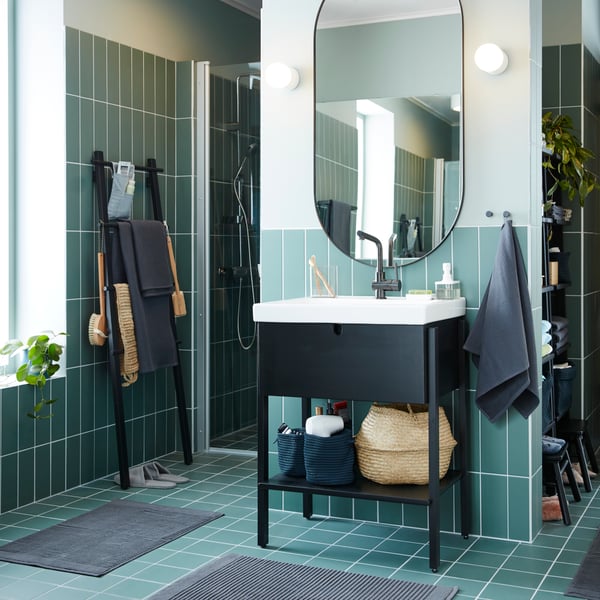 a small blue bathroom with black furniture