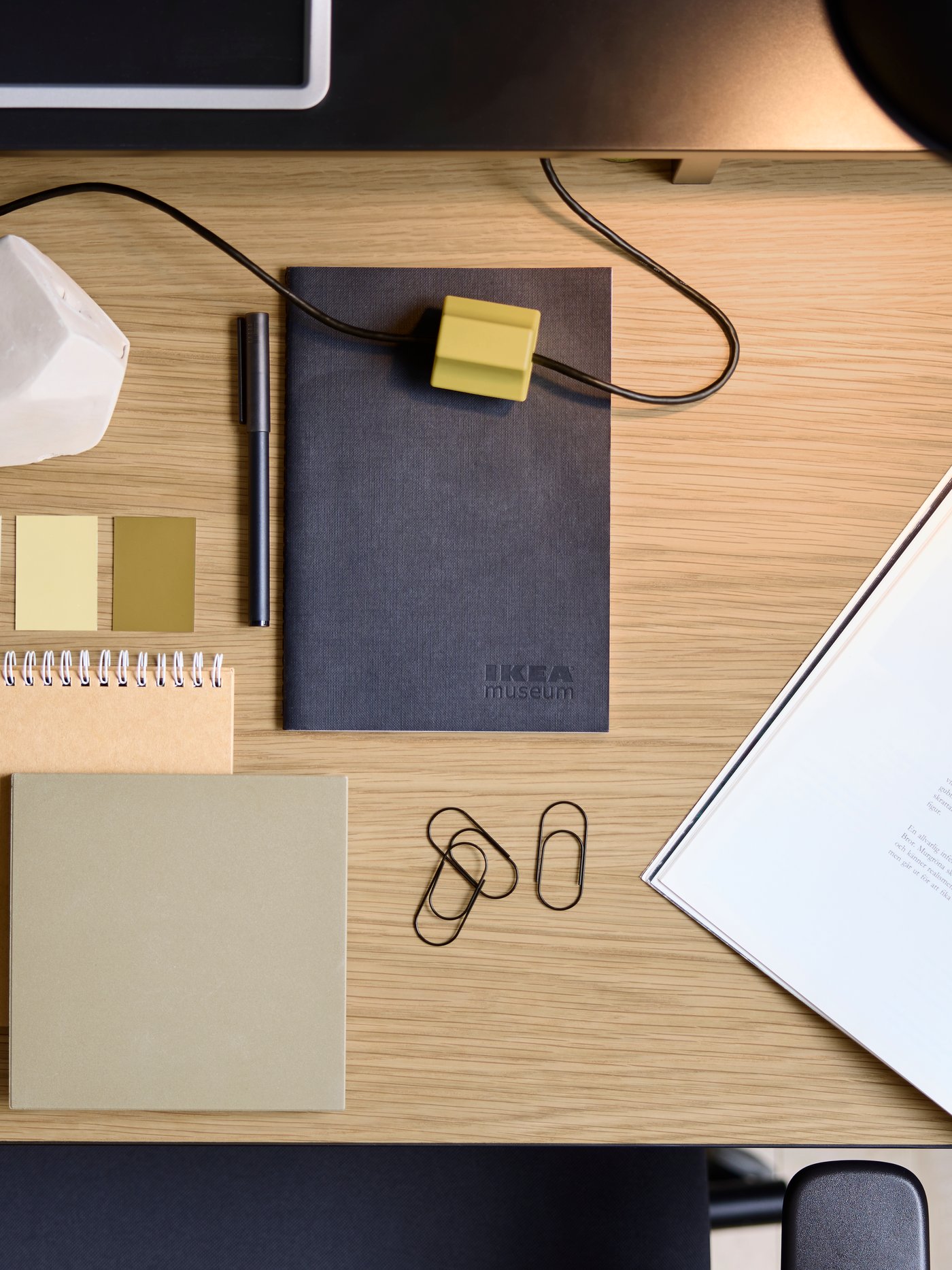 Widok z góry na biurko MULLSJÖ z dębowym blatem, na którym leżą notesy i spinacze.