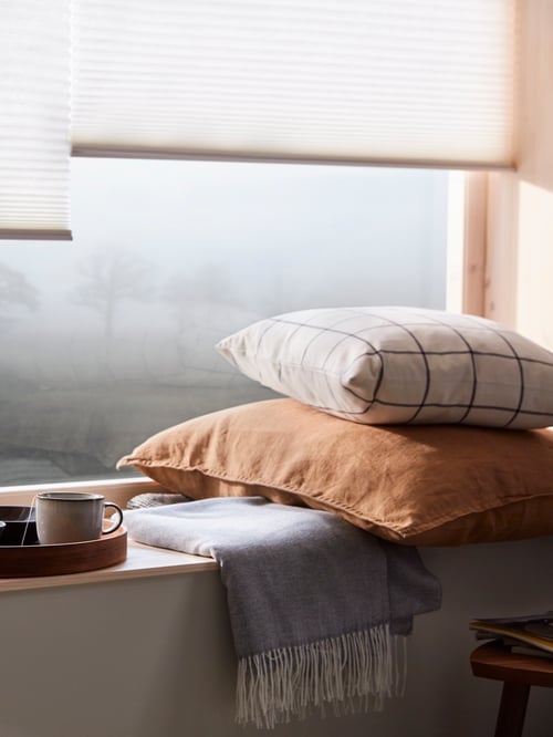Plan rapproché d’une lampe haut-parleur Wi-Fi SYMFONYSK, d’un plateau avec un vase et une tasse, d’un jeté et d’un accessoire dans une housse de coussin DYTÅG.