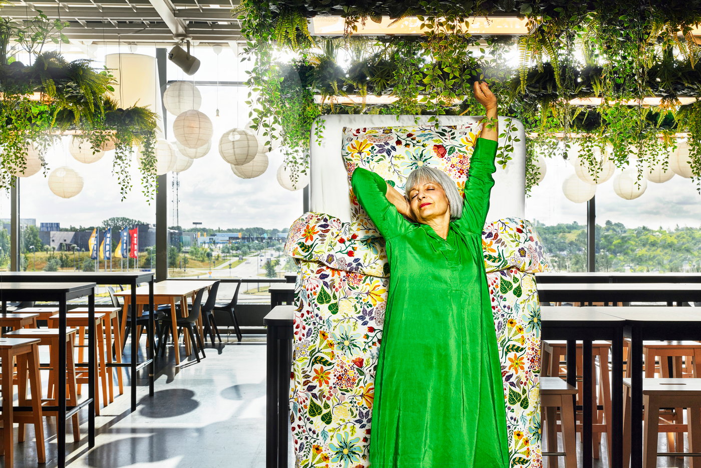 Paní v zelených šatech, v restauraci IKEA, protahující se, čekající na skvělou snídani