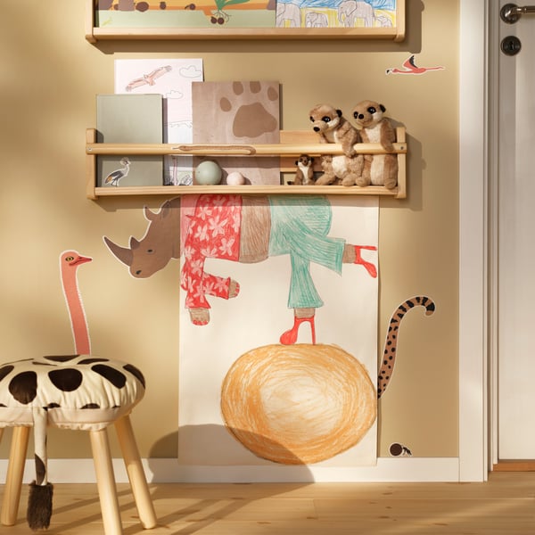 A room with beige walls and wooden shelves is covered with SANDLÖPARE decoration stickers with animals of the savannah.