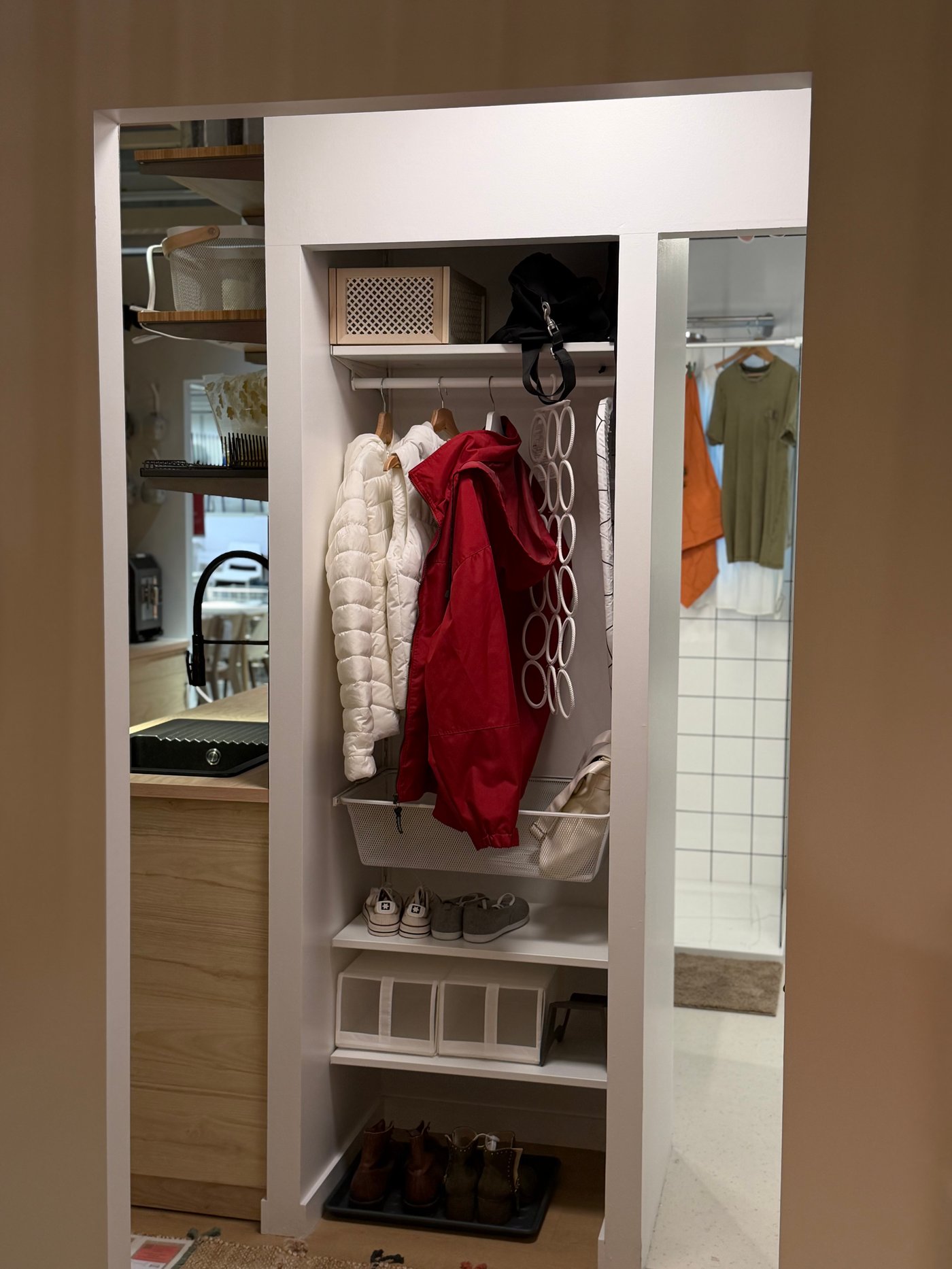 Un dressing d'entrée ouvert avec des manteaux et des chaussures à l'intérieur
