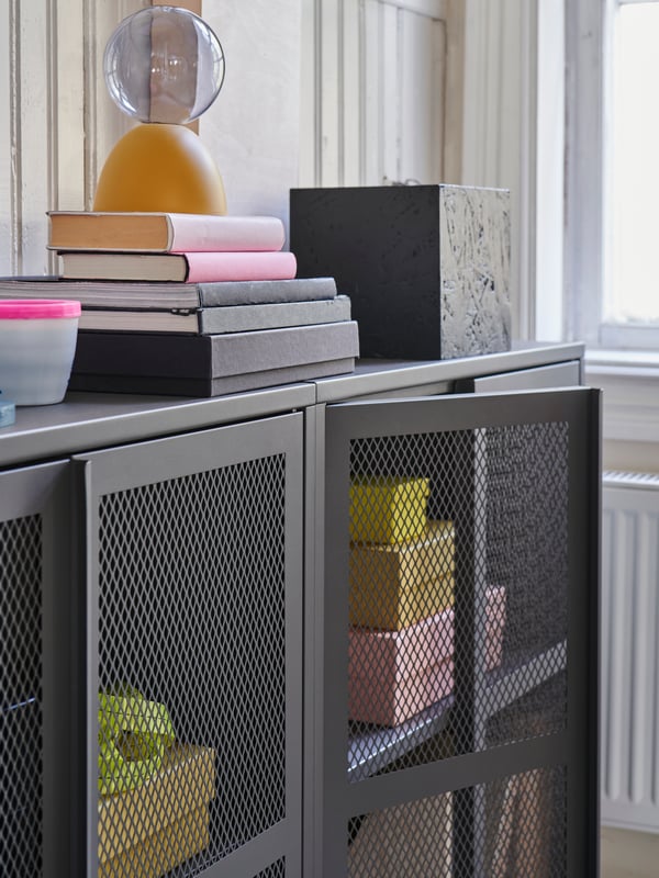 An IVAR cabinet without doors, its shelves full of disorganised books.
