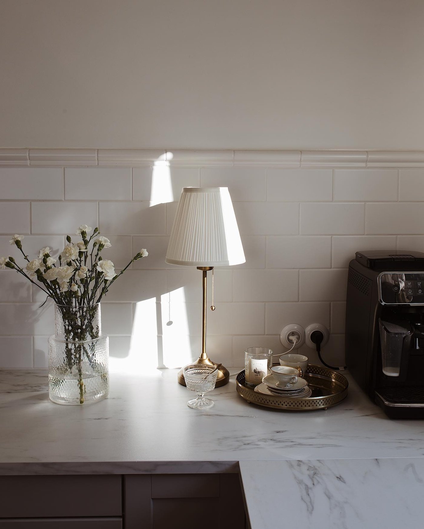 Una lámpara de mesa ÅRSTID blanca/latón en la cocina