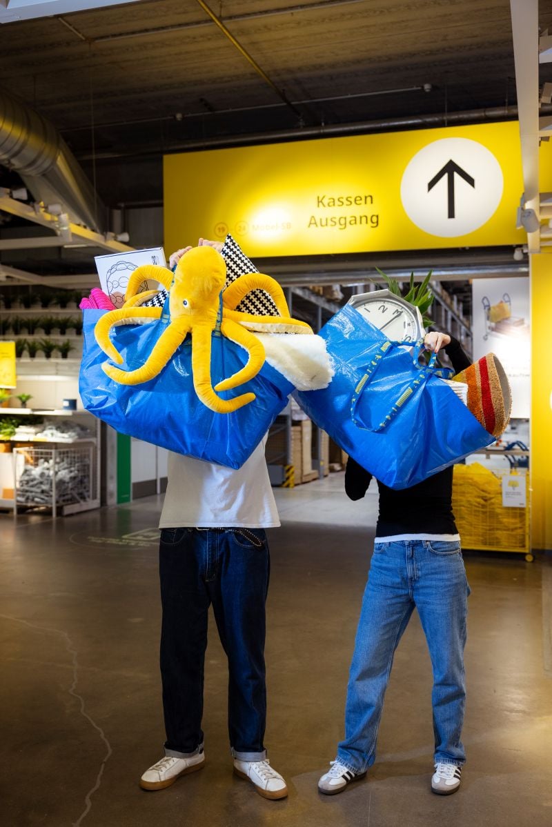 2 Personen halten jeweils eine FRAKTA Tasche gefüllt mit diversen IKEA Artikel in den Händen.