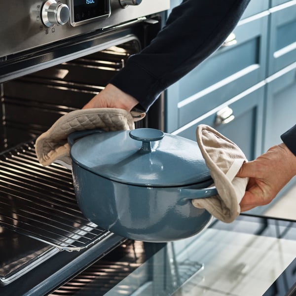 Une cocotte VARDAGEN en fonte émaillée beige clair/gris bleu foncé avec couvercle