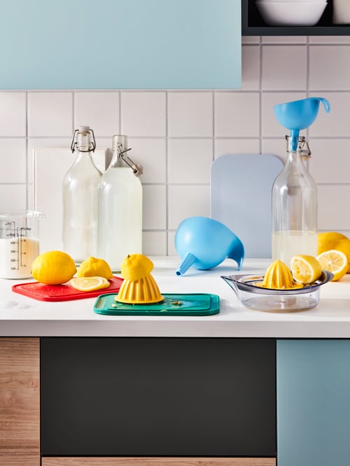 A kitchen worktop in the middle of a lemonade-making session; lemons, a SPRITTA squeezer, CHOSIGT funnels and KORKEN bottles.