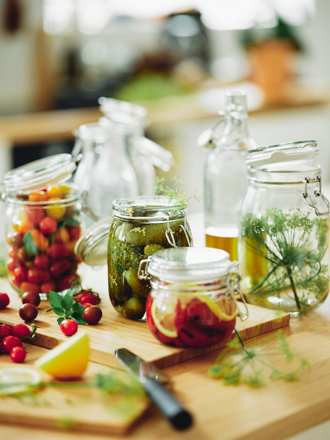 Primer plano de varios botes KORKEN con verduras y frutas sobre una tabla de cortar APTITLIG.