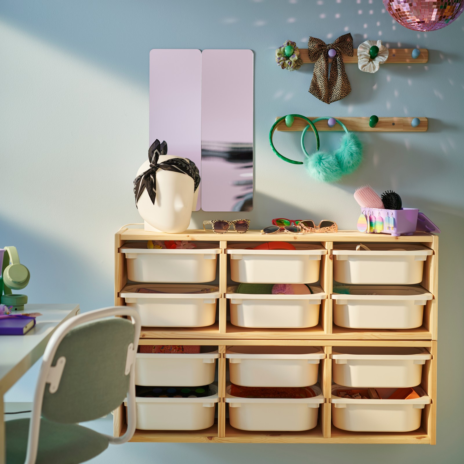 Two light white stained pine TROFAST wall storage frames on a wall with white boxes in. There are two FLISAT knob racks above.