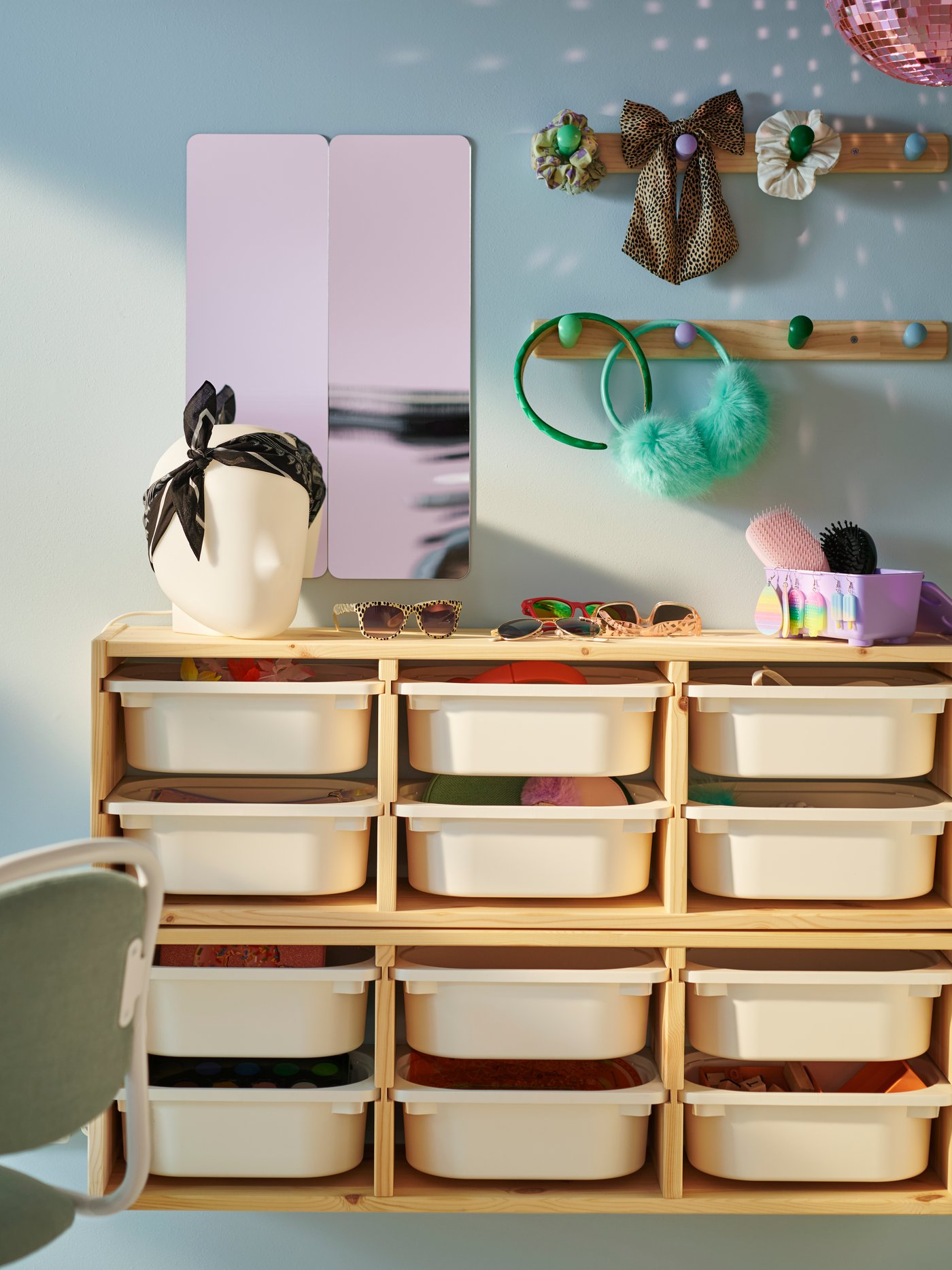 Two light white stained pine TROFAST wall storage frames on a wall with white boxes in. There are two FLISAT knob racks above.