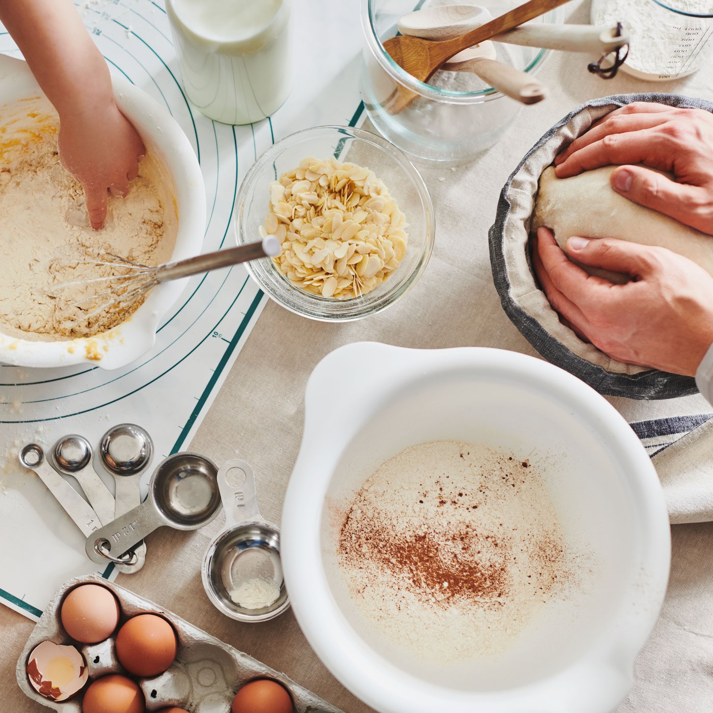 Vista dall'alto di impasti che vengono preparati in diverse ciotole VISPAD. Ci sono 2 persone che stanno cucinando e attorno accessori da cucina in vasi CYLINDER.