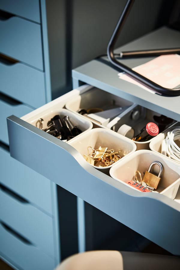 Close-up of a grey-turquoise ALEX desk with small containers in an open desk drawer