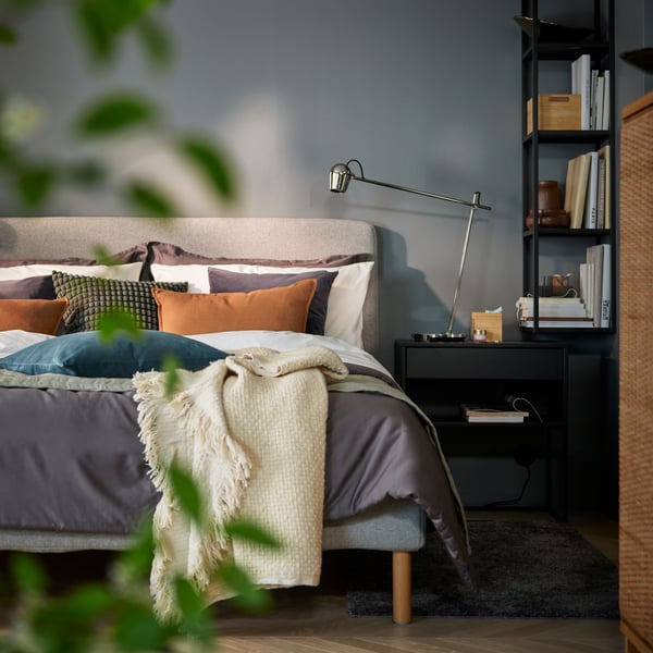 A dark grey SANELA cushion cover in the bedroom
