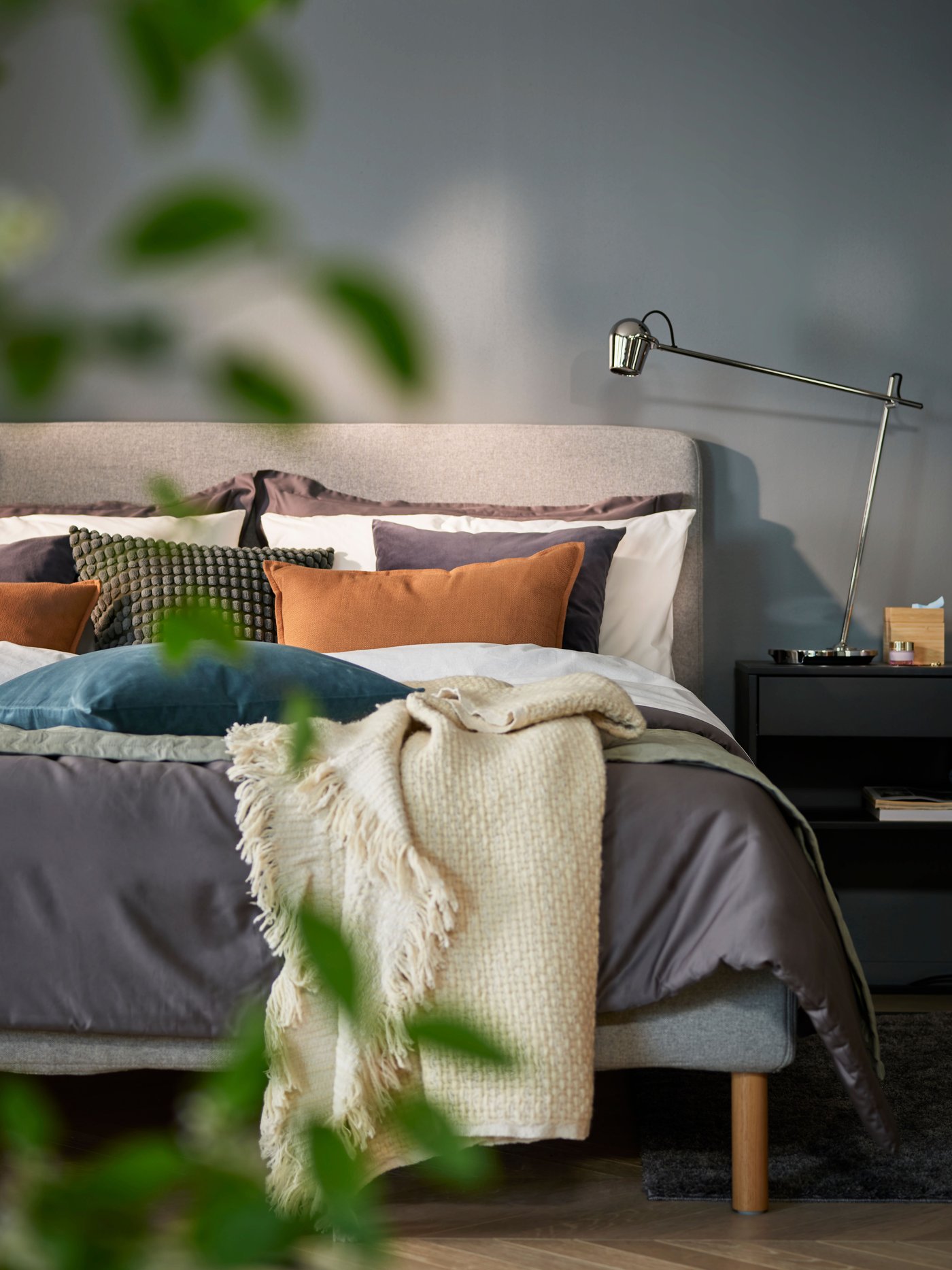 A dark grey SANELA cushion cover in the bedroom