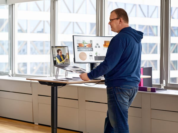 Frau sitzt vor Laptop und erklärt abgebildete Grafik.