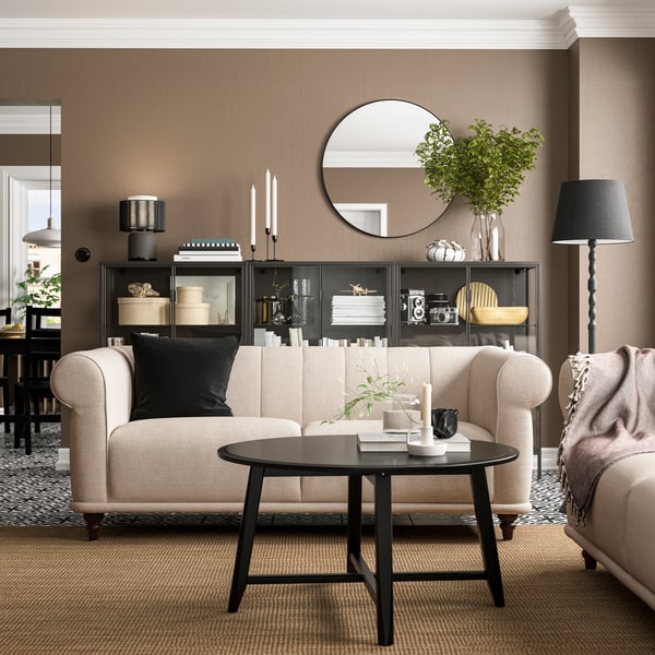 A classic interior with a beige VISKAFORS 2-seat sofa, a black coffee table, and a brown rug on the floor.
