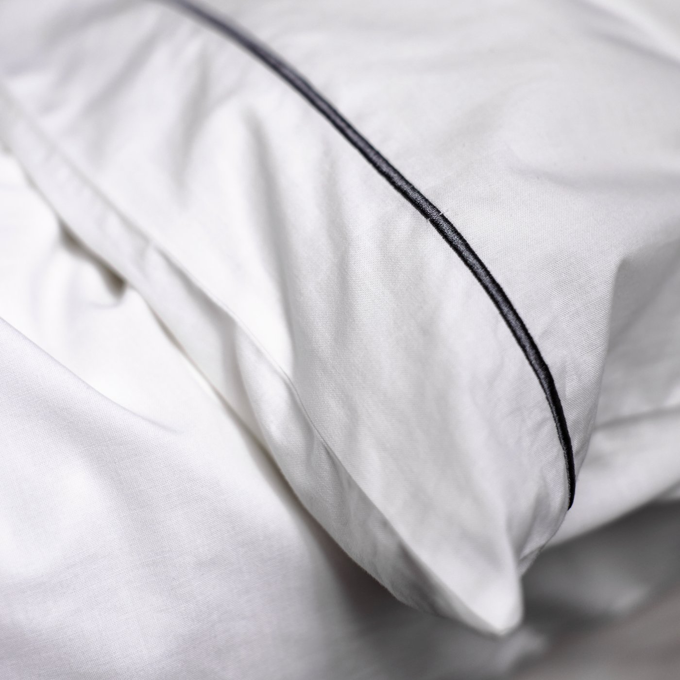 Bantal di dalam sarung bantal SILVERTISTEL berwarna putih/kelabu tua di atas duvet di dalam sarung duvet SILVERTISTEL berwarna putih/kelabu tua.