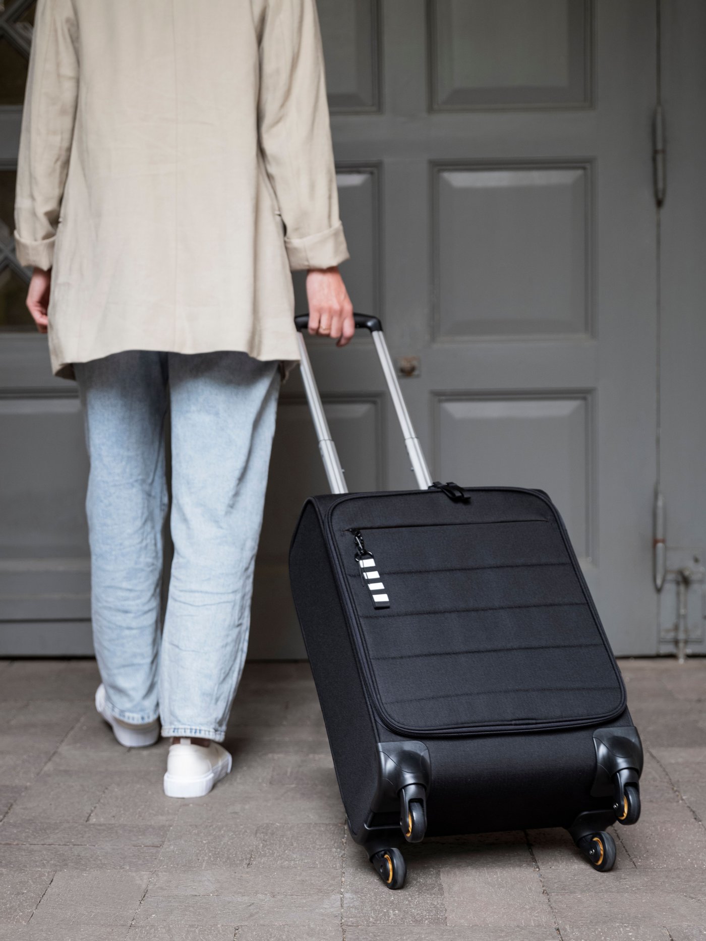 A black VÄRLDENS cabin bag on wheels.
