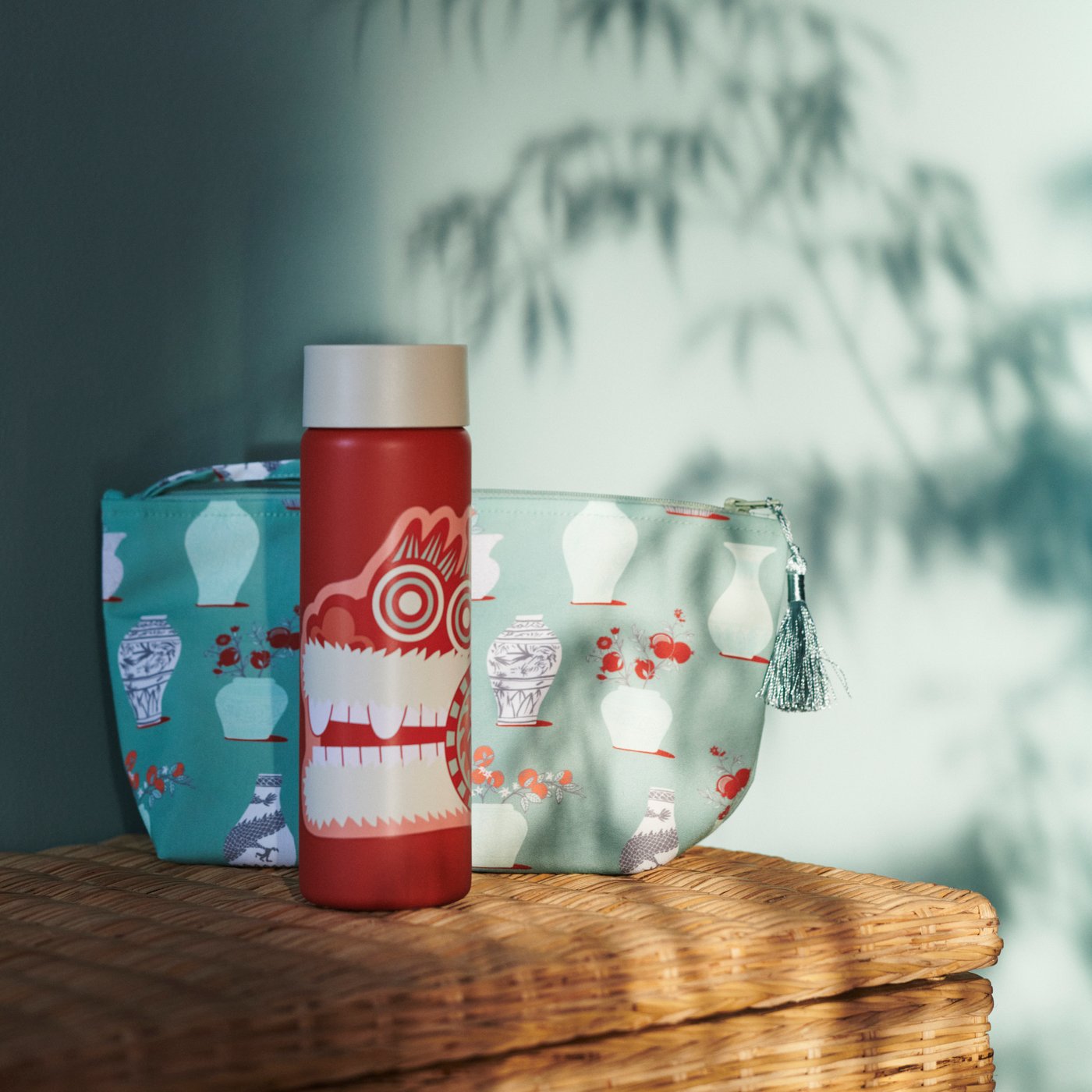 Cahaya yang bertelau-telau memancar koleh bertebat FÖSSTA dan beg perjalanan FÖSSTA yang terletak di atas almari anyaman rotan.