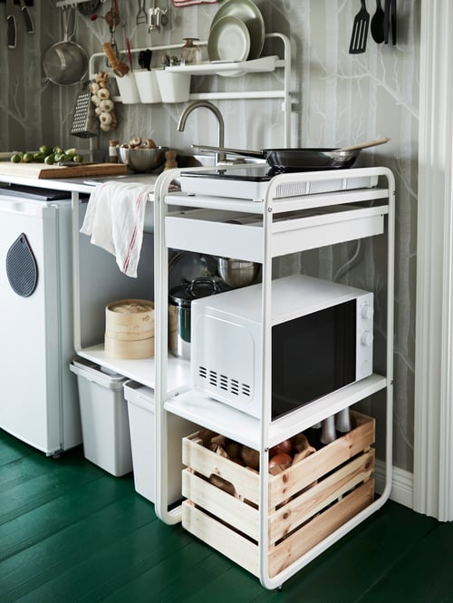 A SUNNERSTA unit kitchen against a grey wall. A white TILLREDA microwave is on the shelf below the hob.