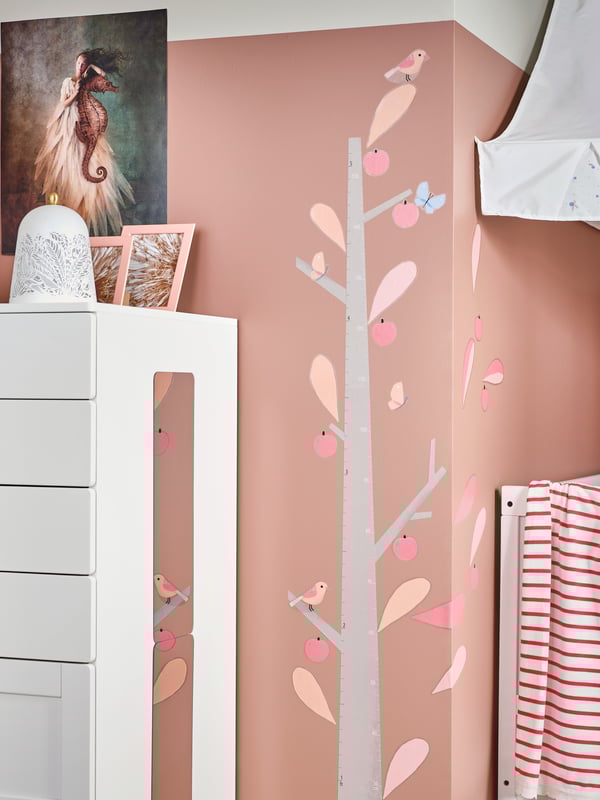 A SMÅSTAD chest of drawers with a mirror on the side stands beside a KINNARED decoration sticker on the wall.