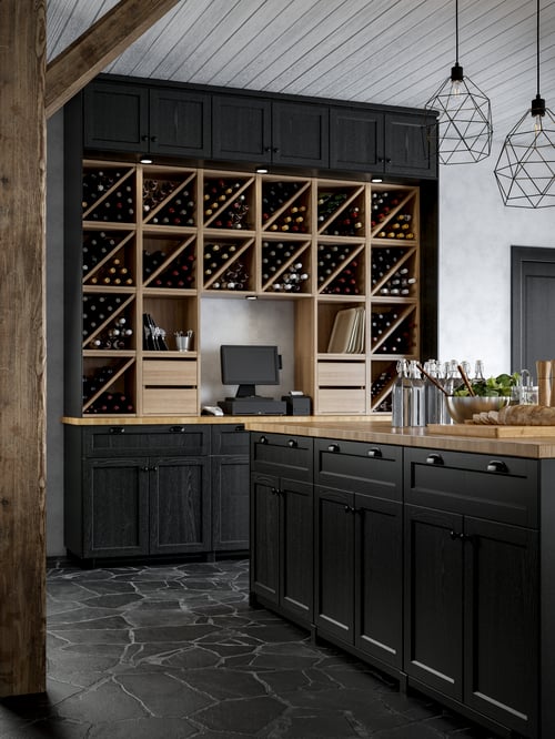 A modern kitchen featuring several square wall wine shelves, square drawer units, cabinets with black doors, and a worktop.