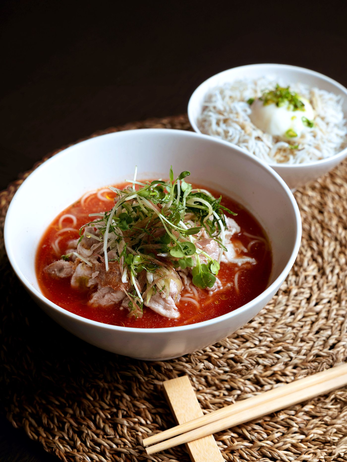 唐辛子入りの赤いスープと白いご飯を木製トレーに載せた食事のテーブルセッティング
